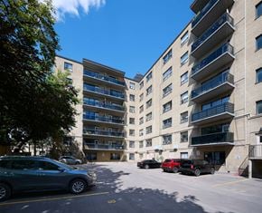 Toronto apartment for rent - A parking lot with cars and apartment buildings.
