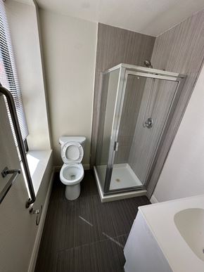 San Rafael apartment for rent - A white toilet sits in a bathroom next to a walk-in shower.