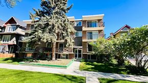 Calgary apartment for rent - an apartment building with a sidewalk and trees in front of it