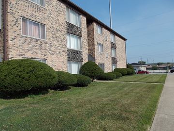 Calumet City apartment for rent - a brick apartment building with a sidewalk and green grass
