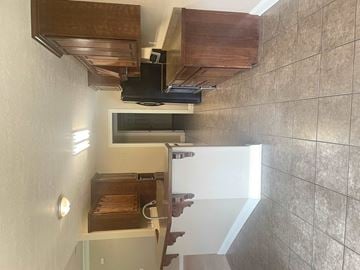 Leesville house for rent - a small kitchen with a refrigerator and a staircase