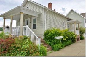 Erie apartment for rent - A small house with a porch and a white picket fence.