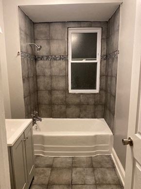 Chicago apartment for rent - a small bathroom with a tub and a window