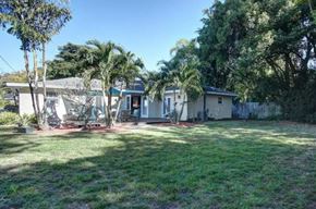Brandenton house for rent - a small white house with palm trees in front of it