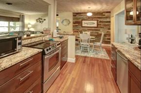 Brandenton house for rent - the kitchen and dining area of a home with wood flooring and granite counter tops