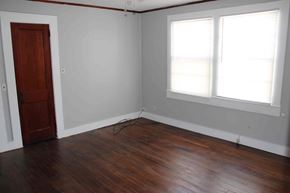 Prentiss house for rent - an empty room with wooden floors and a door and two windows