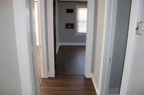 Prentiss house for rent - a hallway with a door to a room with a hard wood floor and a window