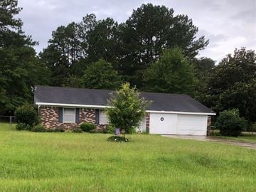 Prentiss house for rent - a small brick house with a tree in front of it in a field
