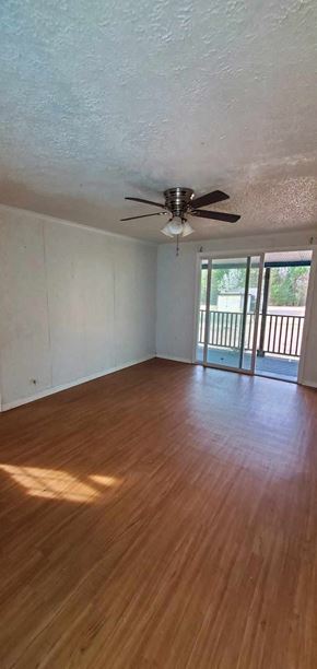 Carson house for rent - an empty living room with wood floors and a ceiling fan