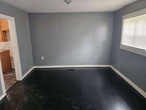 Monticello house for rent - an empty room with a hard wood floor and gray walls