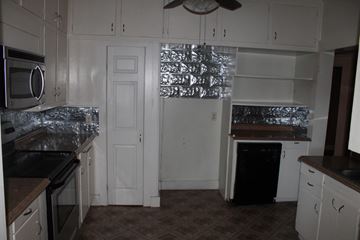 New Hebron house for rent - A kitchen with white cabinets and a black stove top oven.