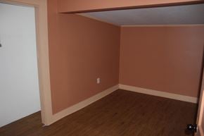 New Hebron house for rent - Empty room with brown walls and wooden floor.
