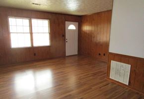 Silver Creek apartment for rent - an empty living room with wood flooring and a white door
