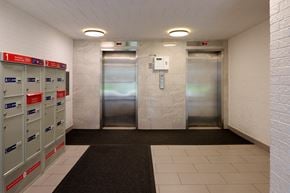 Scarborough apartment for rent - A hallway with a row of mailboxes on the left and two elevators in the middle.