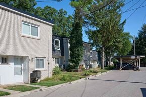 Oakville apartment for rent - A residential street with houses on both sides and a car parked in the driveway.