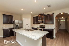 Rockledge house for rent - A kitchen with a marble countertop and dark brown cabinets.