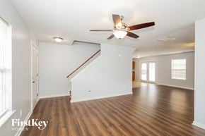 Charlotte house for rent - A spacious room with a wooden floor and a ceiling fan.