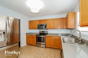Charlotte house for rent - A kitchen with wooden cabinets and a stainless steel refrigerator.