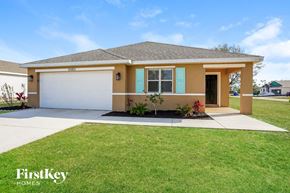 Punta Gorda house for rent - a beige house with a lawn and a garage door