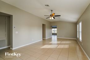 Punta Gorda house for rent - an empty living room with a ceiling fan and tiled floors