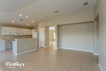 Punta Gorda house for rent - an open kitchen and living room with white cabinets and tile flooring
