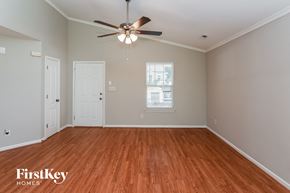 Charlotte house for rent - an empty living room with wood floors and a ceiling fan