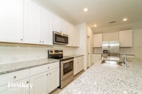 New Braunfels house for rent - a white kitchen with granite counter tops and stainless steel appliances