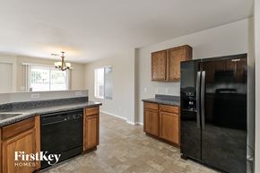 Tucson house for rent - A kitchen with a black fridge and wooden cabinets.