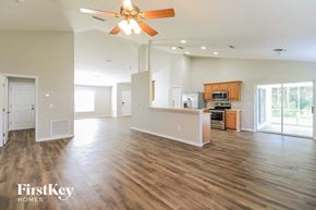 Palm Coast house for rent - A spacious living room with a ceiling fan and wooden flooring.