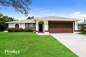Cape Coral house for rent - a house with a driveway and a garage door