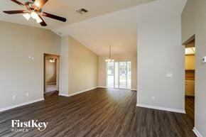 Cape Coral house for rent - an empty living room with wood flooring and a ceiling fan
