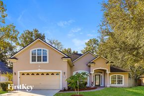 Jacksonville house for rent - a beige house with a garage and trees