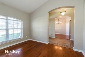 Jacksonville house for rent - an empty living room with a large window and wood floor