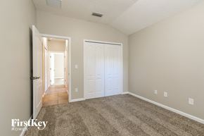 Jacksonville house for rent - a bedroom with a carpeted floor and a white door