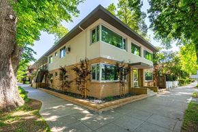 Sacramento apartment for rent - A house with a brown and beige exterior is surrounded by green trees.