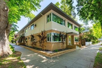Sacramento apartment for rent - A house with a brown and beige exterior is surrounded by green trees.