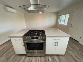 Sacramento apartment for rent - A modern kitchen with a stainless steel stove and white cabinets.