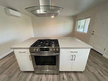 Sacramento apartment for rent - A modern kitchen with a stainless steel stove and white cabinets.