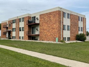 Fargo apartment for rent - a brick apartment building with grass and a sidewalk