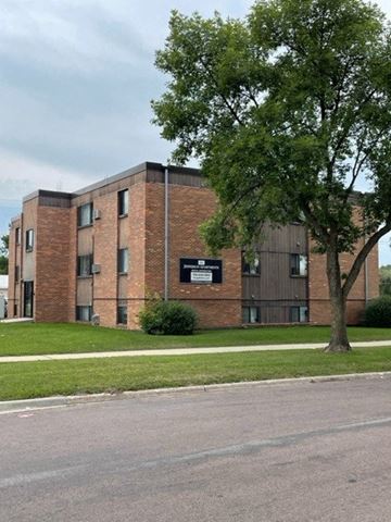 Fargo apartment for rent - a brick building with a tree in front of it