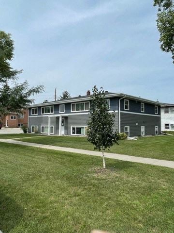 Fargo apartment for rent - an apartment building with a sidewalk in the grass