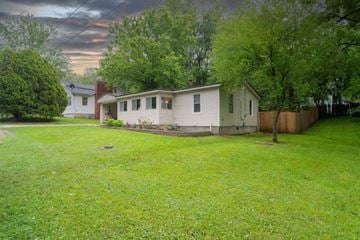 Ozark house for rent - a white house with a yard and a tree
