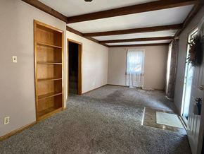 Hammond house for rent - a living room with a carpeted floor and a wooden door
