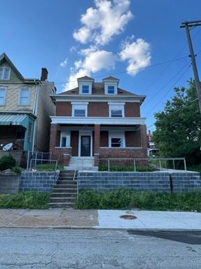 Mount Oliver house for rent - the front of a brick house with stairs in front of it