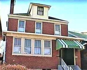 Mckeesport house for rent - an old brick house with a green and white awning