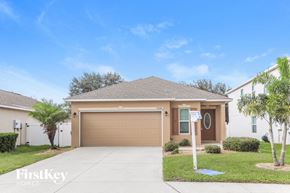 Palmetto house for rent - a home with a garage door and a palm tree