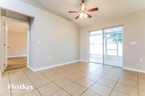Palmetto house for rent - an empty living room with a ceiling fan and a sliding glass door