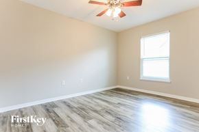 Palmetto house for rent - a living room with wood floors and a ceiling fan