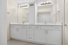 North Riverside apartment for rent - A white bathroom with a vanity and a mirror.