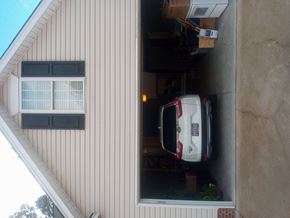 Columbia house for rent - A white car is parked in a garage attached to a house.